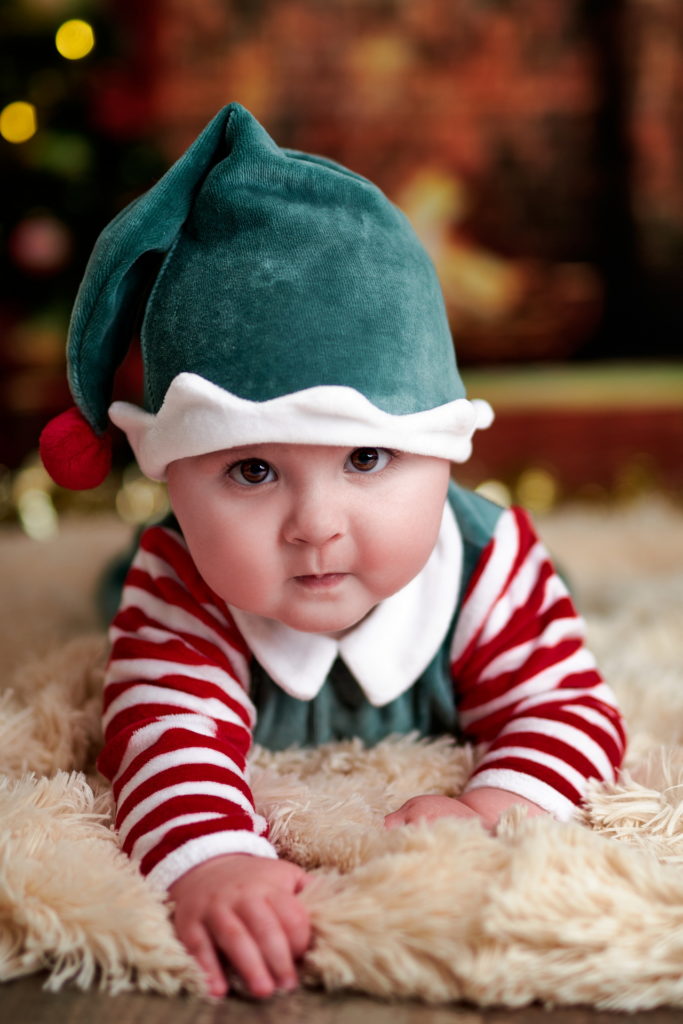 photo d'un bébé très mignon habillé en lutin allongé sur une couverture à long poils très doux