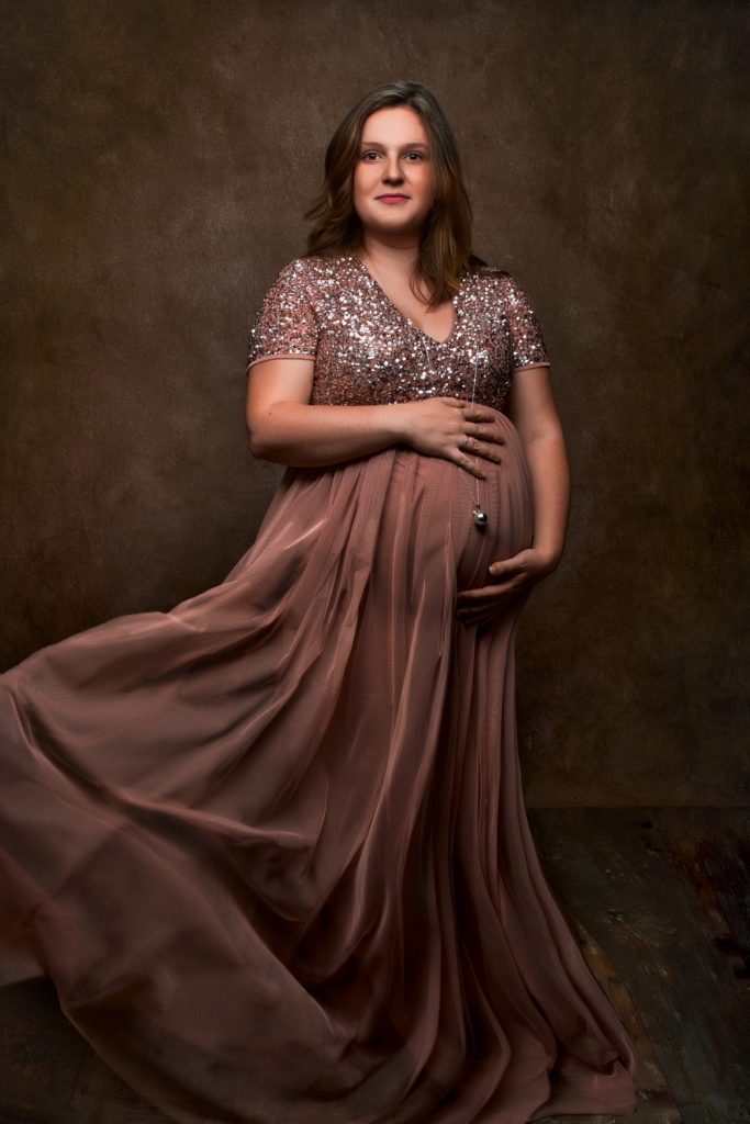 photo studio grossesse femme enceinte vêtue d'une robe en tulle rose qui vole