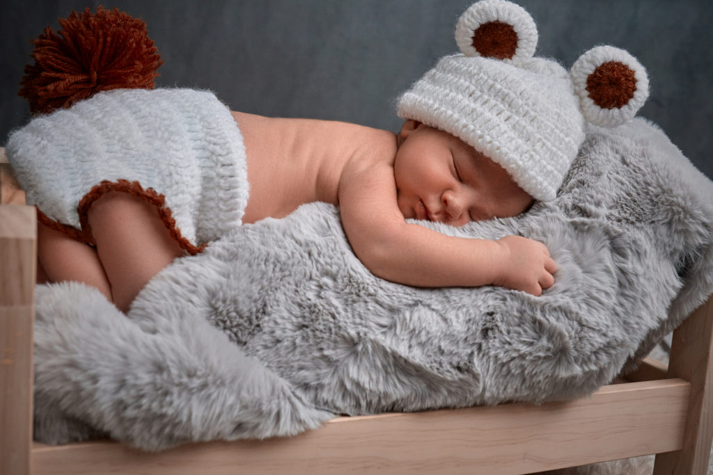bébé endormi sur une couverture très douce dans un mini lit de poupée, il est venu un short à pompon et d'un bonnet avec des oreilles