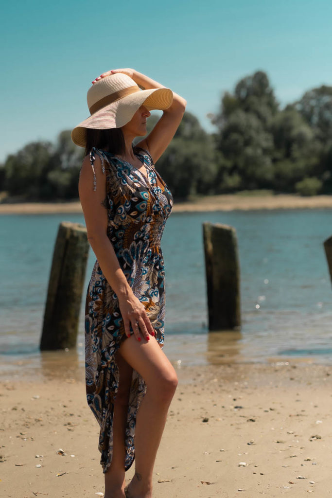 portrait d'un femme en robe d'été et chapeau sur une plage en bord de seine prés de Rouen